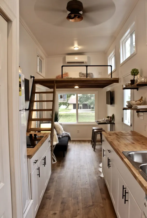 Long galley kitchen inside an ADU with a sleeping loft at the far end
