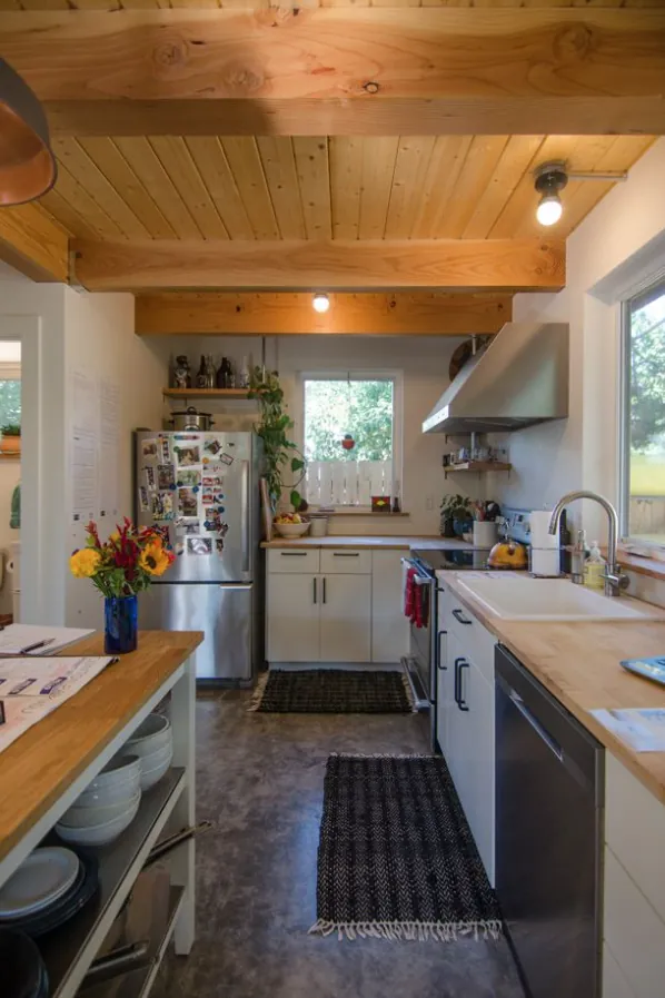 ADU kitchen with a pine ceiling, a butcher-block island and a window over the sink