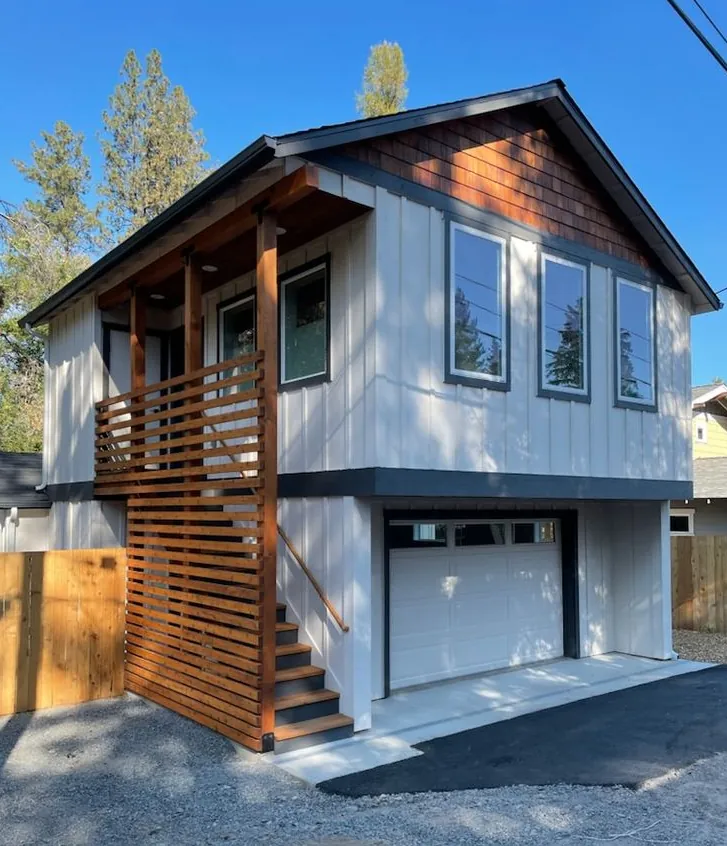 Garage suite on a back lane with a cedar-slat stair up to the living space over the garage